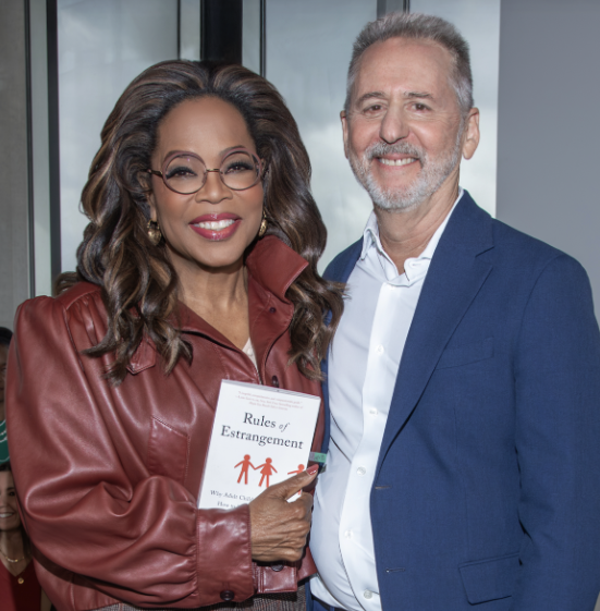 Dr. Joshua Coleman with Oprah Winfrey, holding a copy of Rules of Estrangement